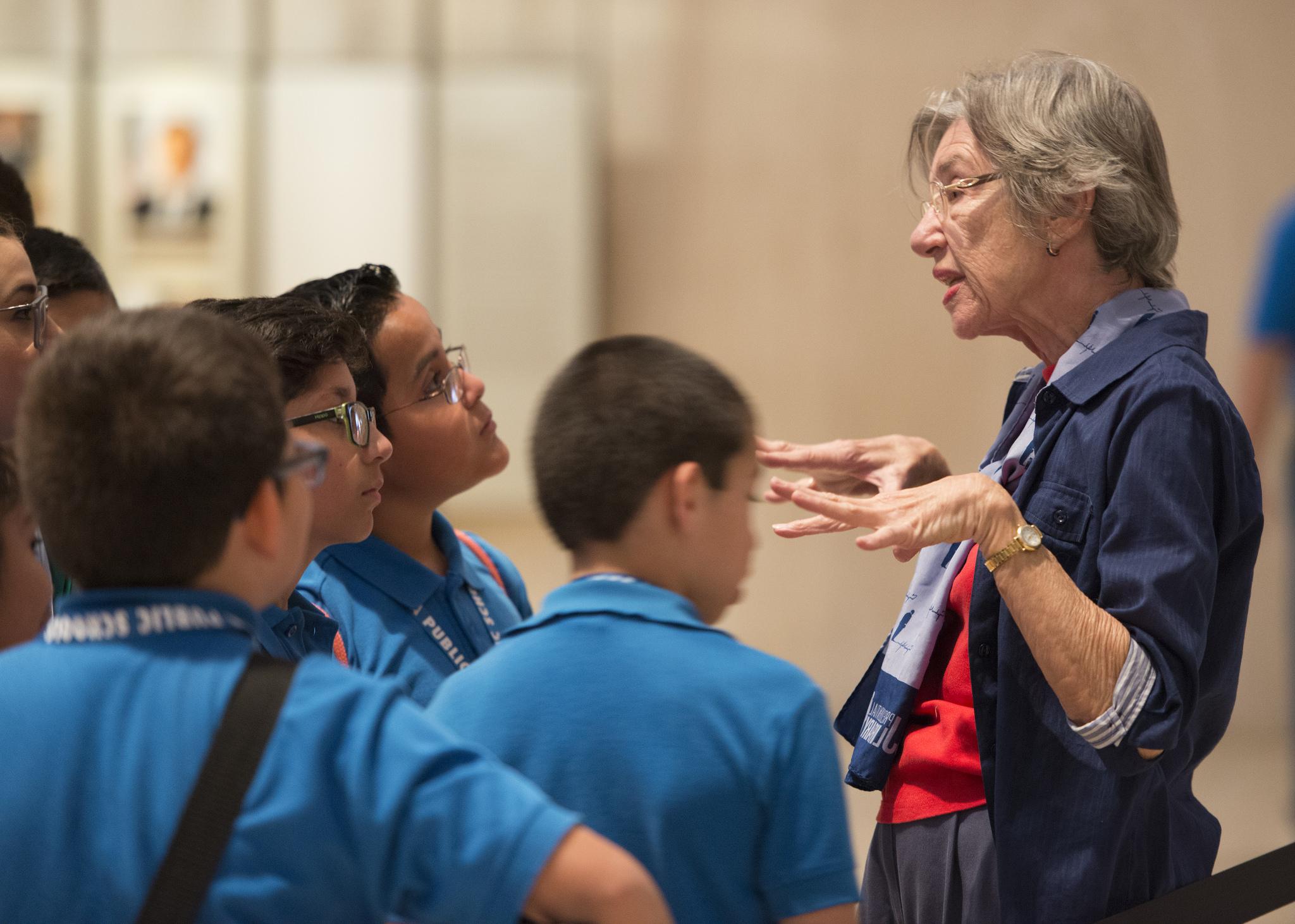 LBJ Library volunteer speaks to students in the Great Hall of the LBJ Library